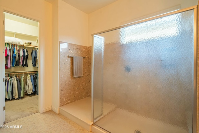 bathroom with a shower with door and tile patterned flooring