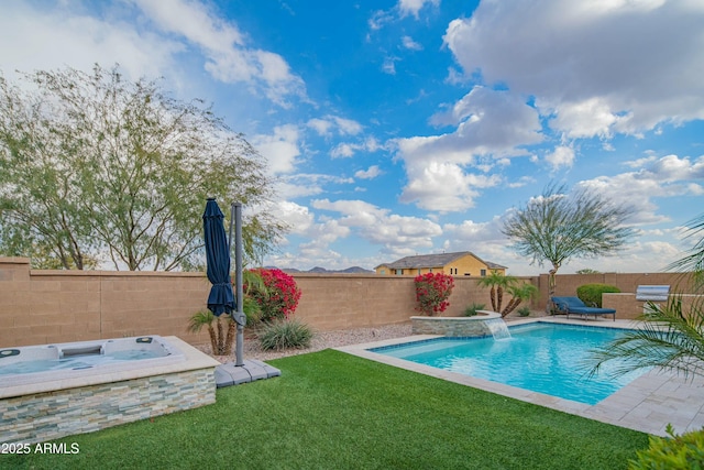 view of swimming pool with pool water feature, a yard, and an outdoor hot tub