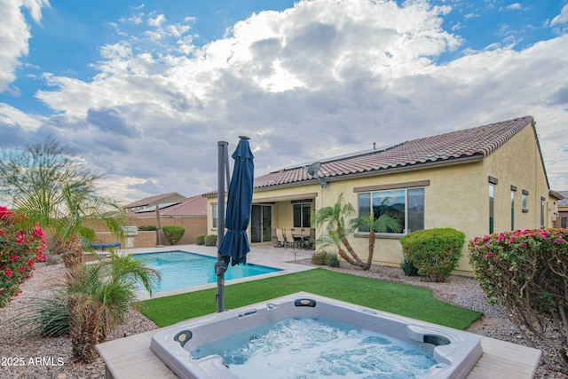 view of pool featuring an outdoor hot tub, a yard, and a patio