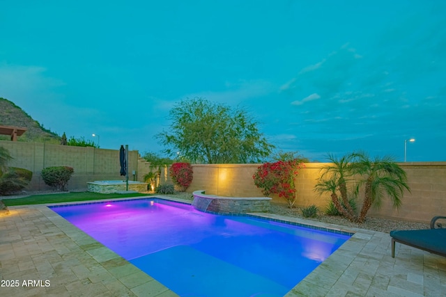 view of swimming pool featuring pool water feature and a patio area