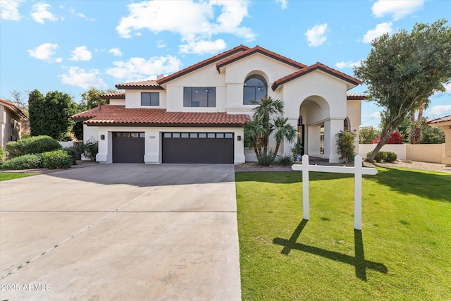 mediterranean / spanish home featuring a tile roof, stucco siding, concrete driveway, an attached garage, and a front lawn