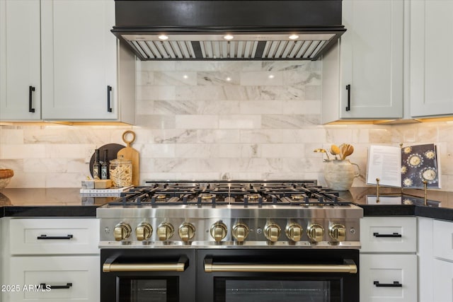 kitchen featuring double oven range, dark countertops, backsplash, and custom range hood