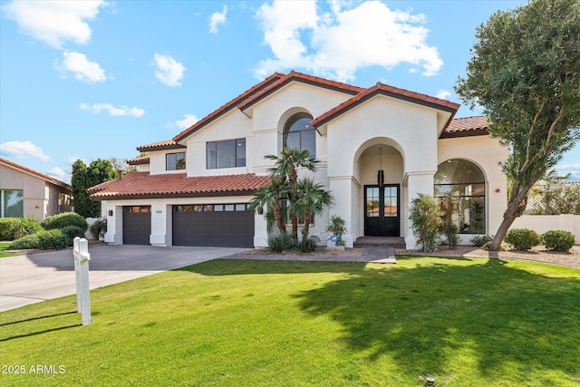 mediterranean / spanish-style home with a tile roof, a front lawn, concrete driveway, and stucco siding