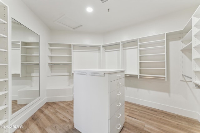 spacious closet featuring light wood finished floors and attic access