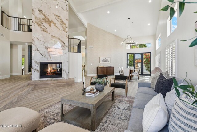 living area with a high ceiling, a fireplace, and baseboards