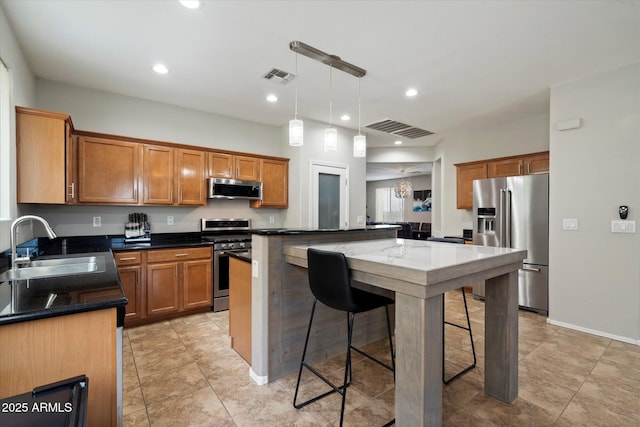 2328 W Calle Marita, Phoenix, AZ 85085 - kitchen featuring stainless steel appliances, a sink, a kitchen island, a breakfast bar, and brown cabinets