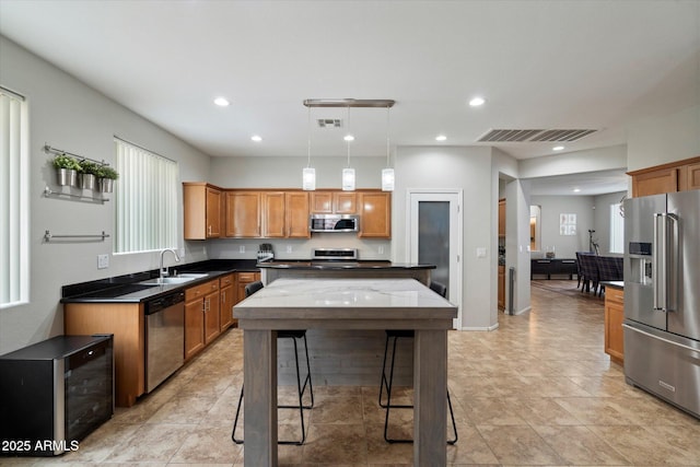 2328 W Calle Marita, Phoenix, AZ 85085 - kitchen with appliances with stainless steel finishes, a sink, recessed lighting, brown cabinets, and pendant lighting