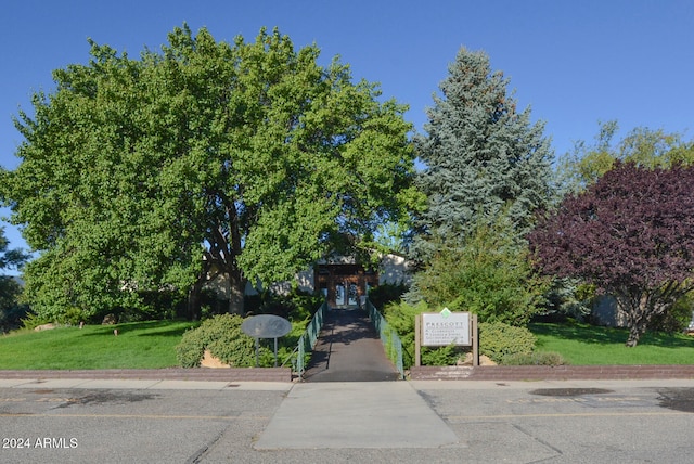 view of property hidden behind natural elements featuring a front lawn