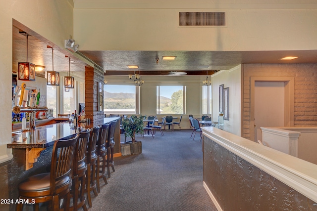 bar featuring carpet and hanging light fixtures