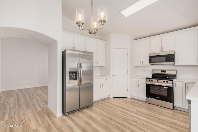 kitchen featuring light countertops, stainless steel appliances, white cabinets, and light wood-type flooring