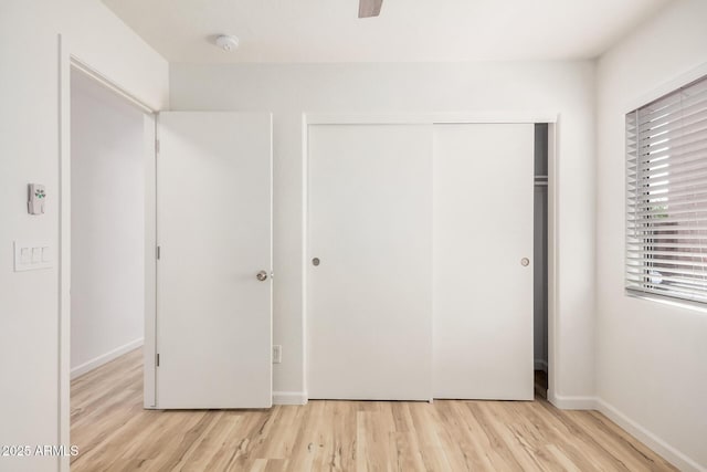 unfurnished bedroom featuring baseboards, a closet, and wood finished floors