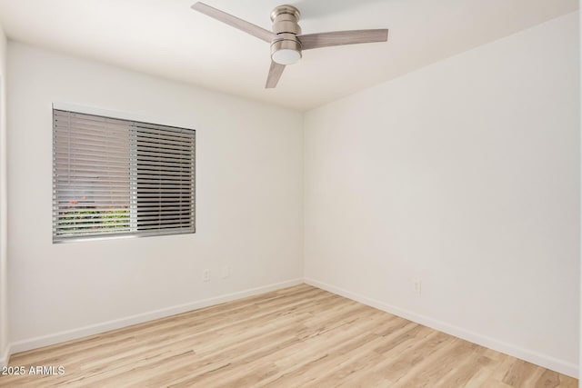 spare room featuring a ceiling fan, baseboards, and wood finished floors