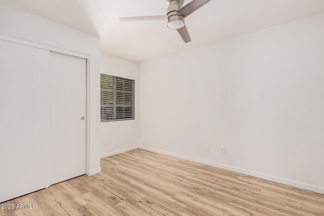 unfurnished bedroom with light wood-style floors, baseboards, ceiling fan, and a closet