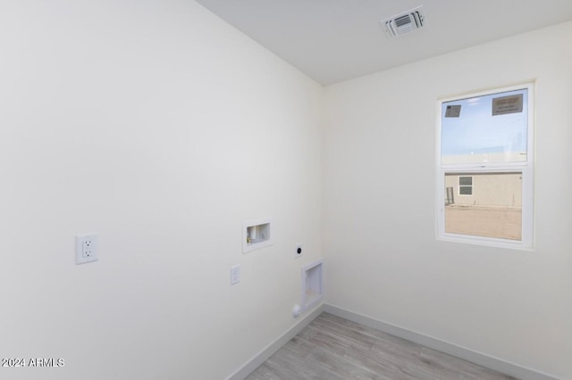 laundry area featuring electric dryer hookup, light hardwood / wood-style flooring, and washer hookup