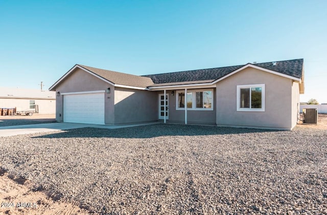 ranch-style home with a garage and central air condition unit