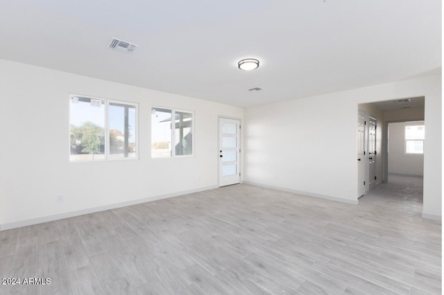 unfurnished room with plenty of natural light and light hardwood / wood-style floors