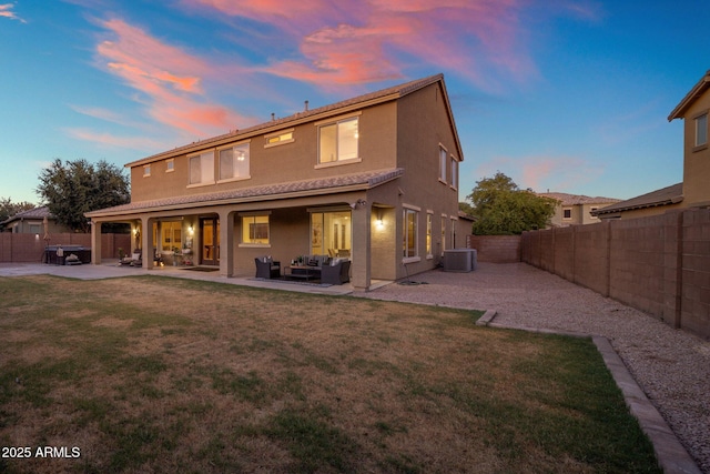 7616 S Sorrell Ln, Gilbert, AZ 85298 - back of property at dusk with outdoor lounge area, a fenced backyard, a patio area, and stucco siding