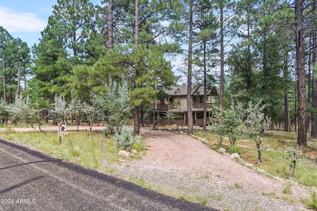 view of property hidden behind natural elements featuring a wooden deck