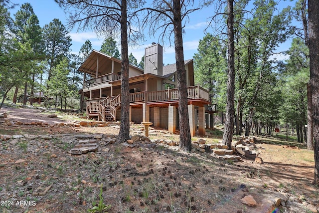 rear view of house featuring a wooden deck