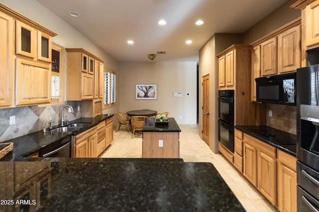 kitchen featuring backsplash, black appliances, sink, dark stone countertops, and a kitchen island