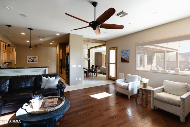 living room with hardwood / wood-style flooring, ceiling fan, and sink