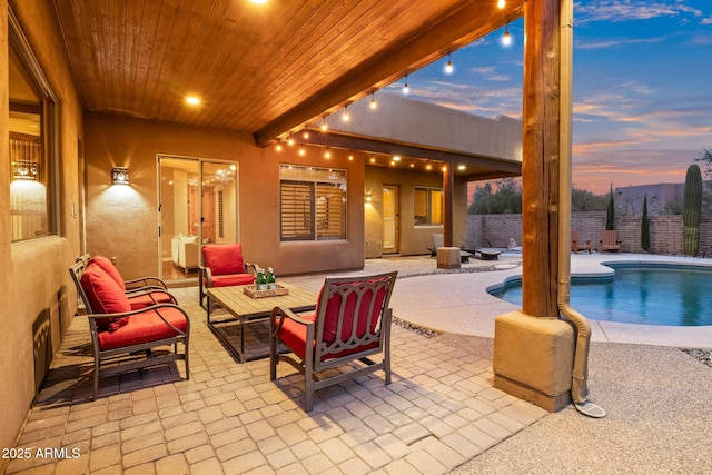 patio terrace at dusk featuring an outdoor hangout area and a fenced in pool