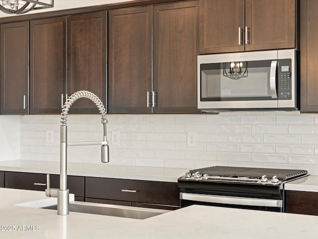 kitchen with sink, stainless steel appliances, backsplash, and dark brown cabinetry