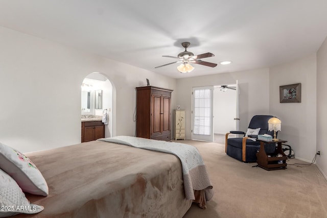 bedroom featuring ensuite bath, ceiling fan, and light colored carpet