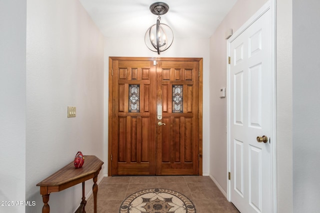 tiled foyer featuring a chandelier