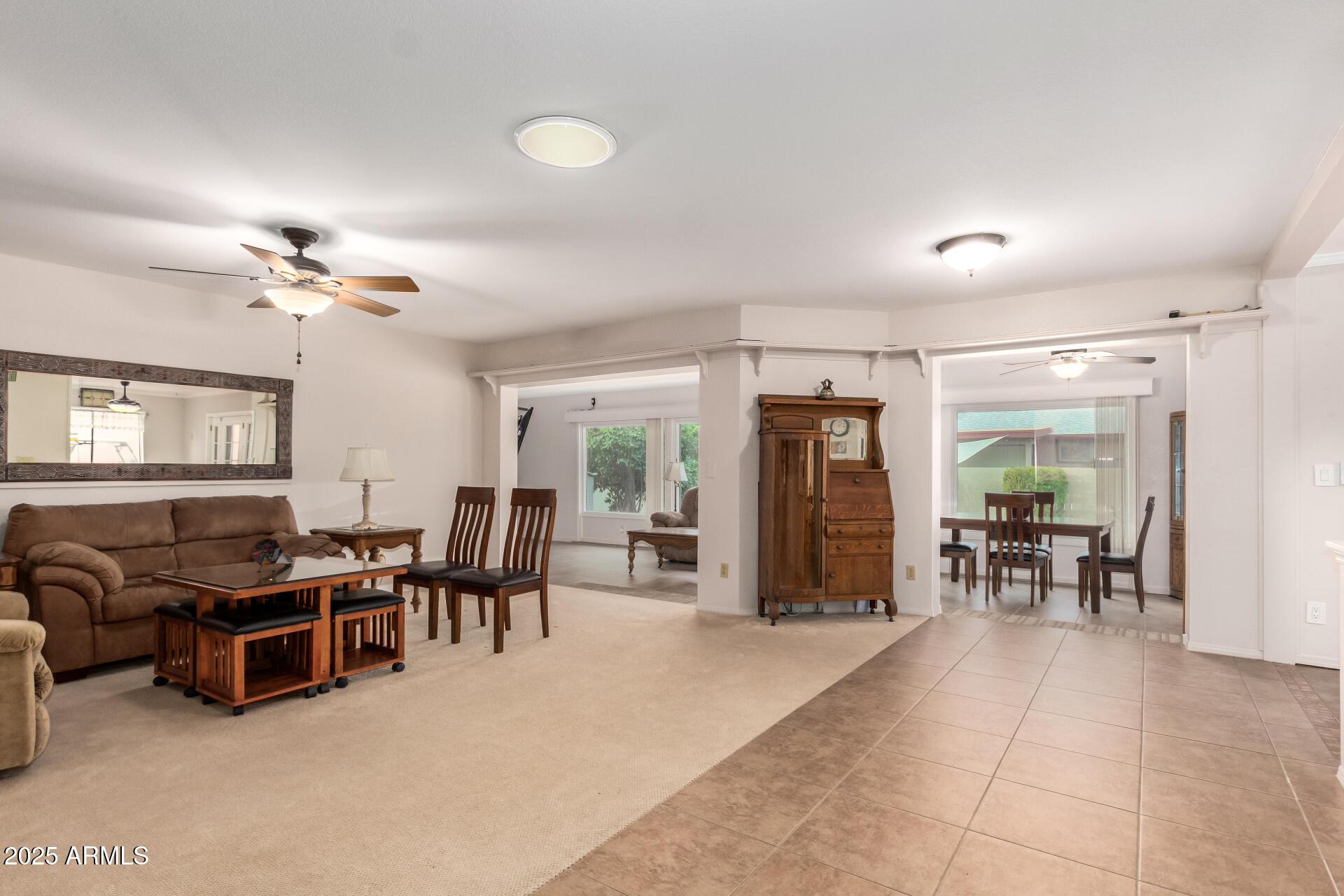 carpeted living room with ceiling fan