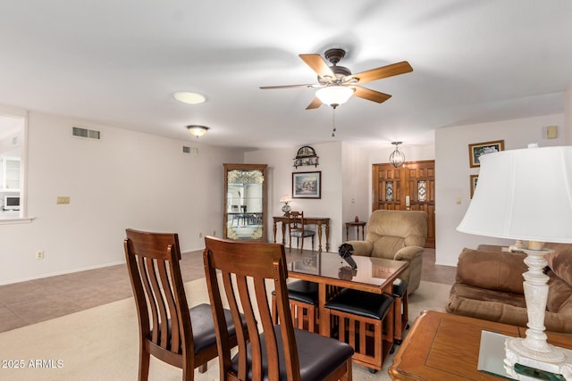 dining area with ceiling fan and light carpet