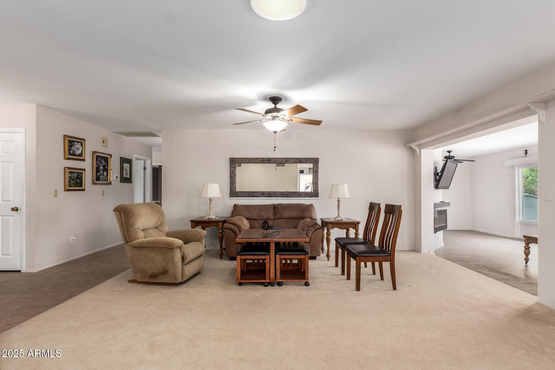 carpeted living room with ceiling fan