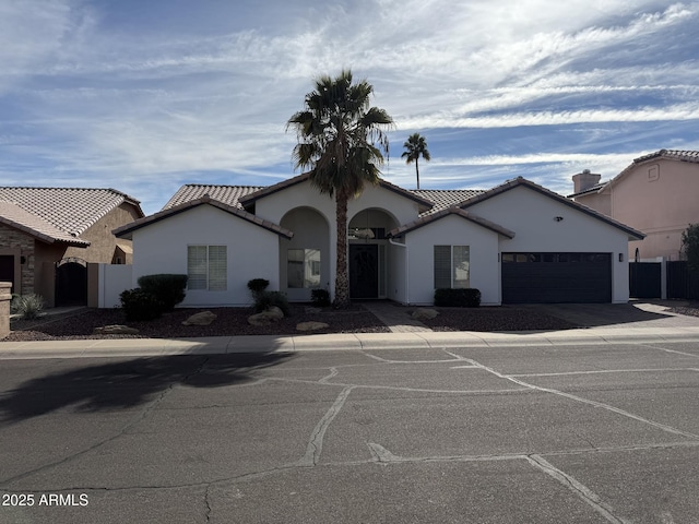 mediterranean / spanish house with driveway, an attached garage, and stucco siding