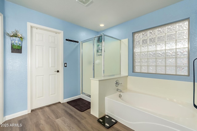 bathroom with hardwood / wood-style flooring and separate shower and tub