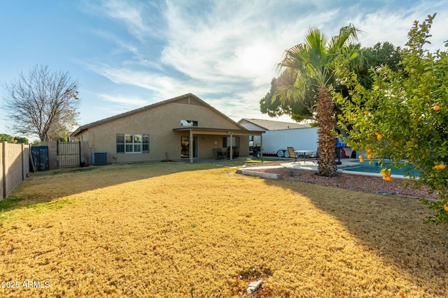 rear view of property with central AC, a patio area, and a lawn