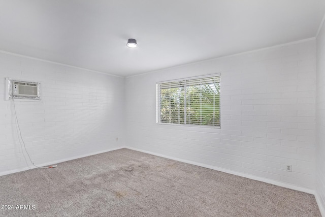 carpeted empty room featuring a wall mounted AC, ornamental molding, and brick wall