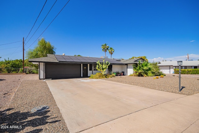 view of front facade featuring solar panels, stucco siding, a garage, and concrete driveway
