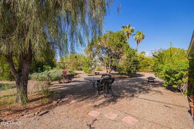 view of yard featuring a fire pit and a patio