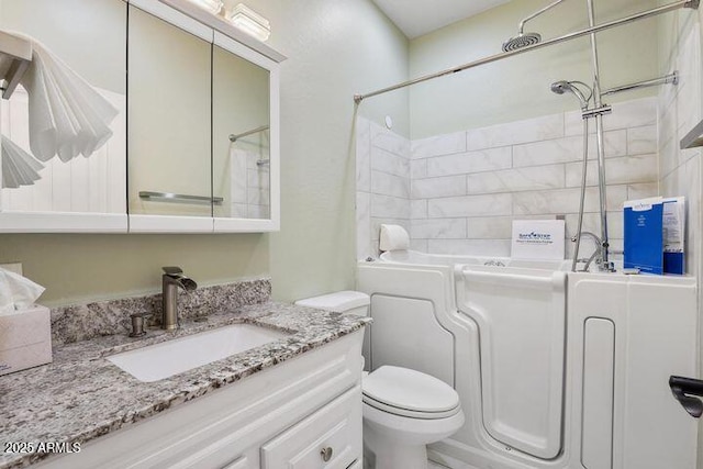 bathroom with toilet, a shower, and vanity