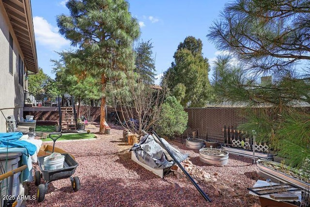 view of yard featuring a fenced backyard, a vegetable garden, and stairs