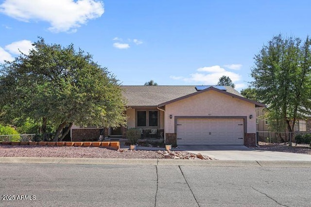 ranch-style house featuring a garage, concrete driveway, fence, and stucco siding