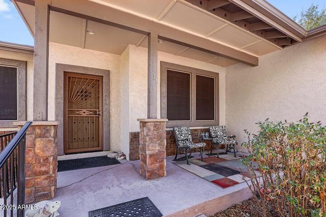 doorway to property with stone siding and stucco siding