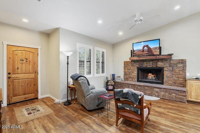 living area with a fireplace, baseboards, wood finished floors, and recessed lighting