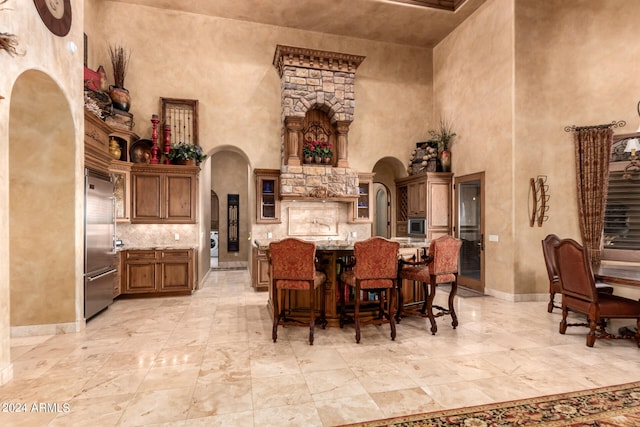 dining space featuring light tile patterned flooring and a towering ceiling