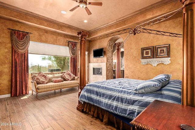 bedroom with ceiling fan, wood-type flooring, ornamental molding, and ornate columns