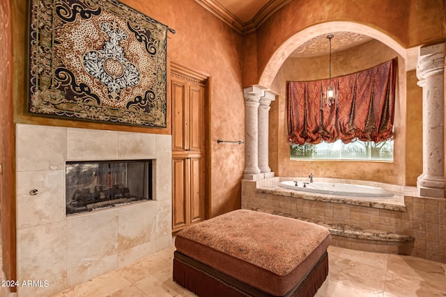 bathroom featuring a tile fireplace, decorative columns, ornamental molding, and tiled bath