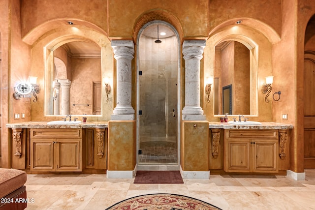 bathroom with decorative columns, a shower with door, dual vanity, and tile patterned flooring