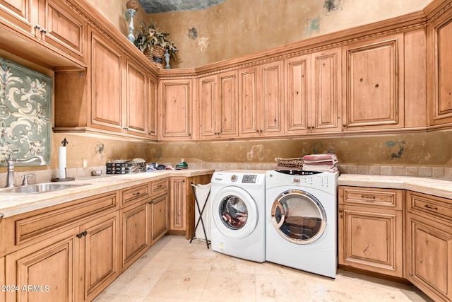 laundry area with light tile patterned flooring, cabinets, separate washer and dryer, and sink