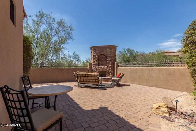 view of patio / terrace featuring an outdoor stone fireplace