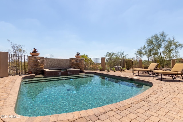 view of pool featuring a patio and an in ground hot tub